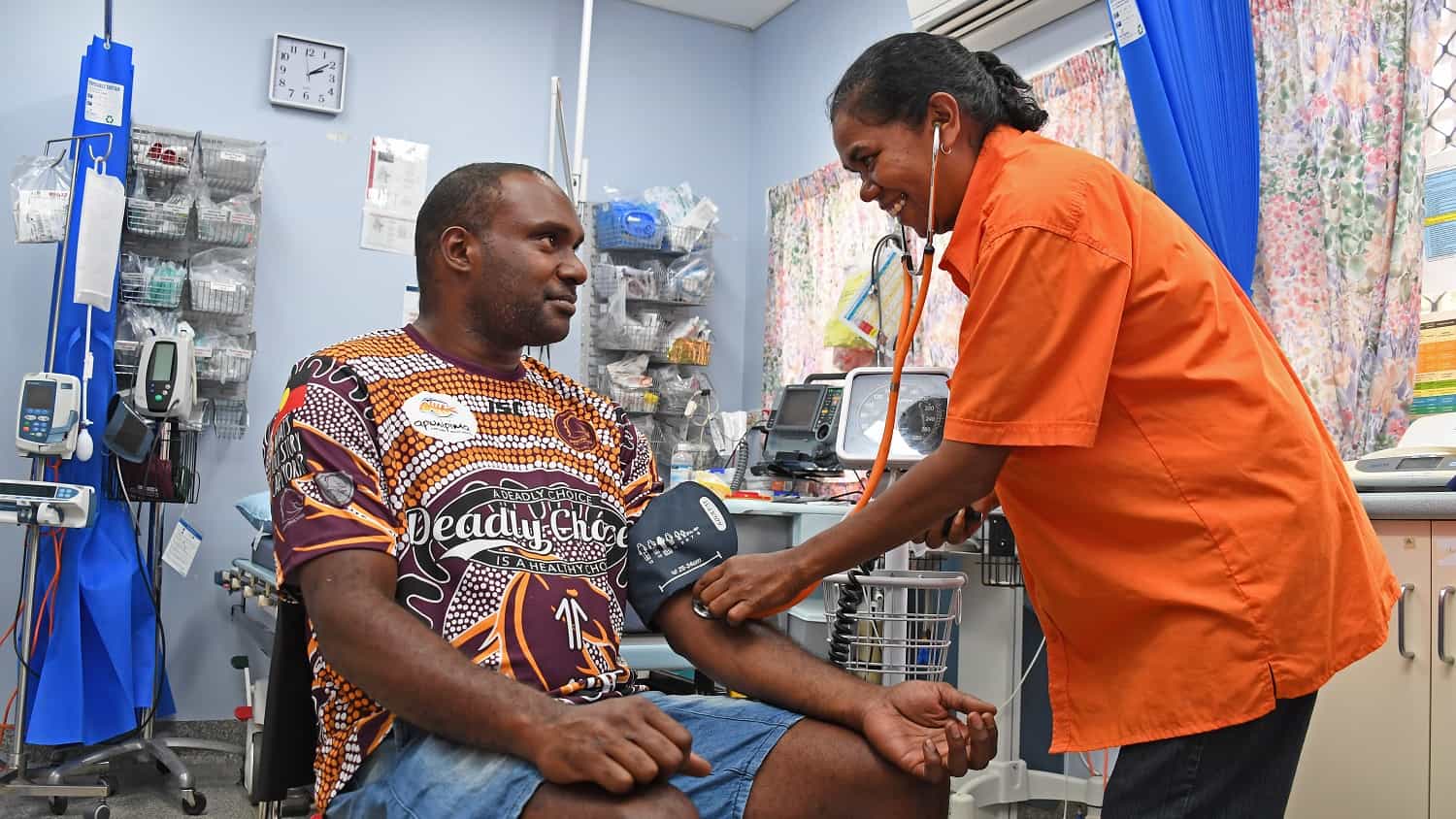 Image of an Apunipima healthcare worker taking a patient's blood pressure