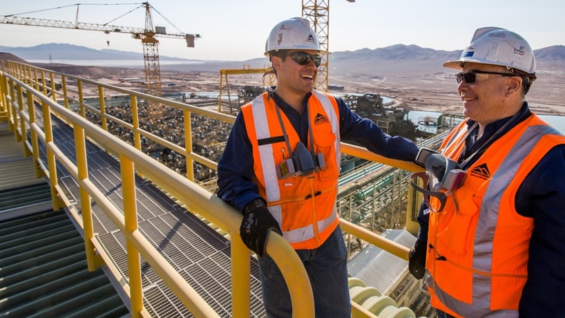 Two people in BHP PPE on site looking over mine