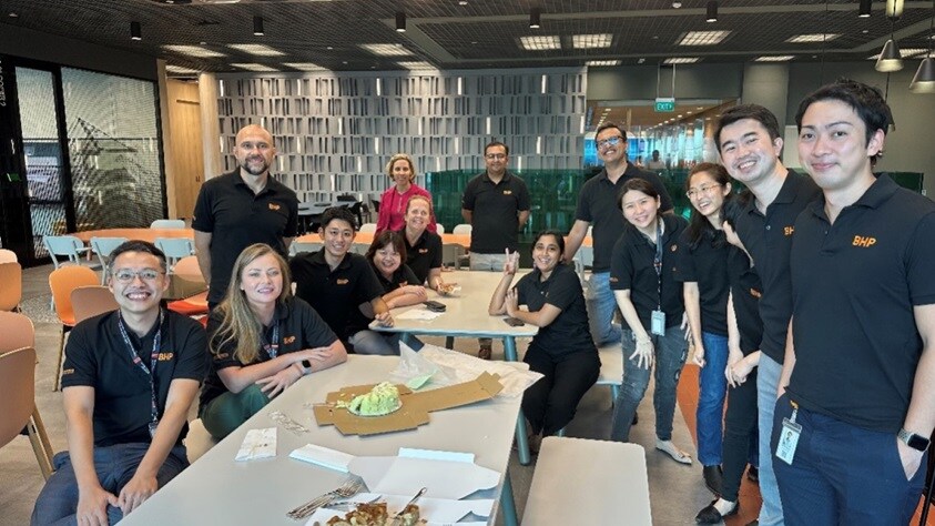 some of the BHP team in Singapore shown in lunch room smiling and eating