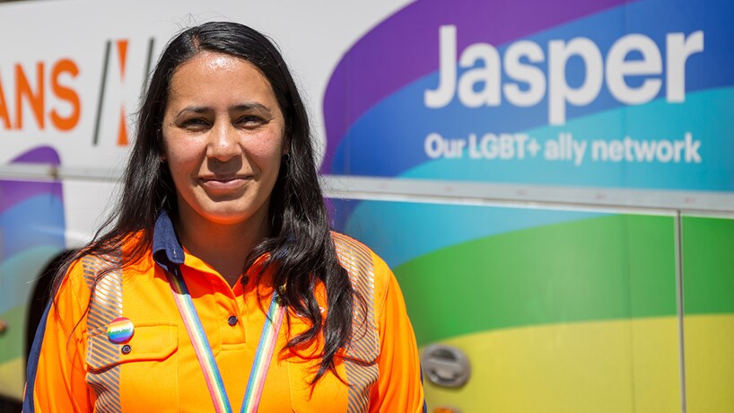 Jasper bus with woman in BHP rainbow lanyard and orange high vis shown smiling
