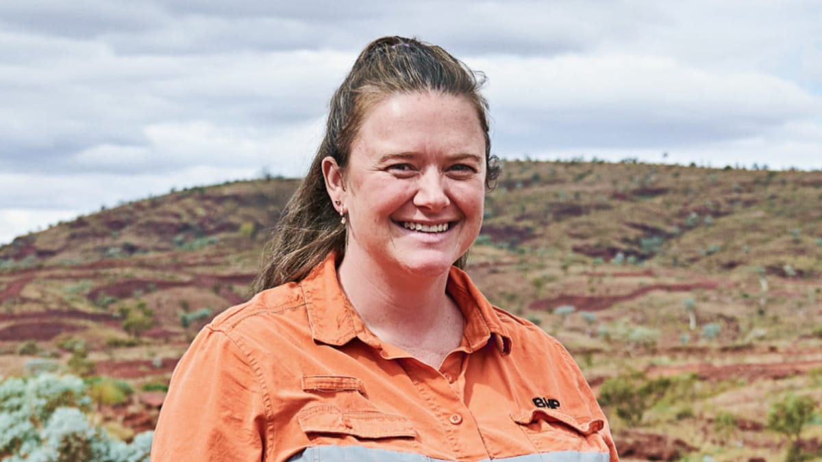 Megan shown smiling with landscape in background