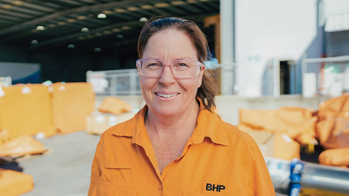 Sonia shown smiling with workshop in the background
