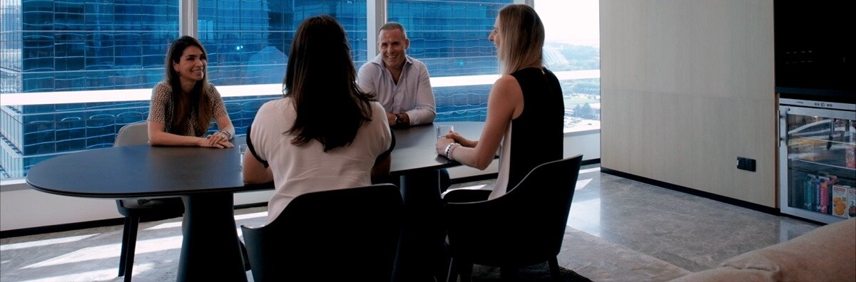 Four people sit around a table, talking and smiling