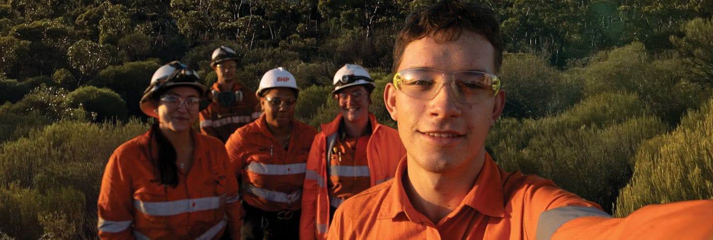 FIVE APPRENTICES IN A FIELD ONE MALE TAKING THE PHOTO UP CLOSE FOUR BEHIND