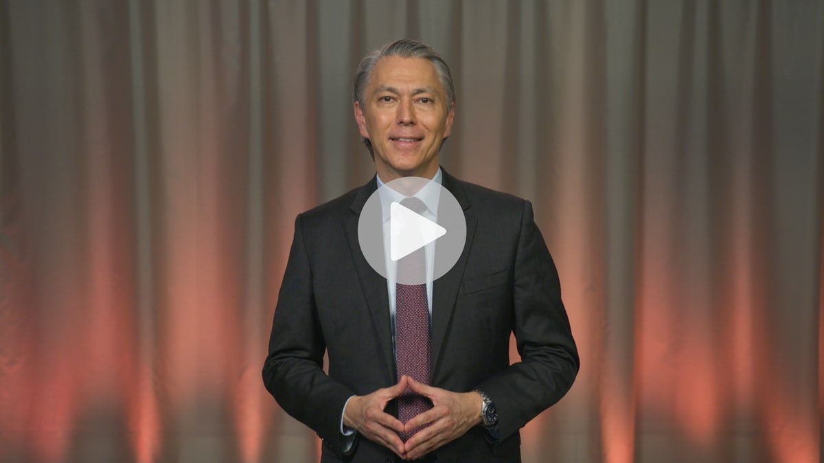 Mike Henry, CEO, standing in dark suit and smiling