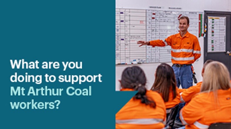 Man at front of room at whiteboard talking to audience with text saying "What are you doing to support Mt Arthur Coal workers?"