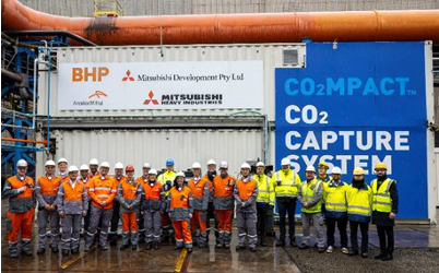 people outside a board showing BHP initiatives