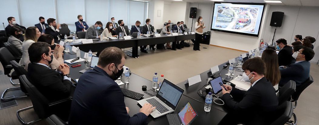 people around a table and on a screen