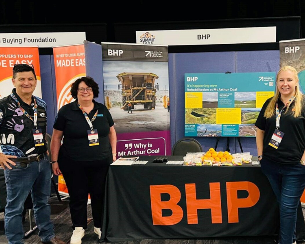 3 people standing at BHP exhibit at Indigenous Chamber of Commerce Summit in 2025