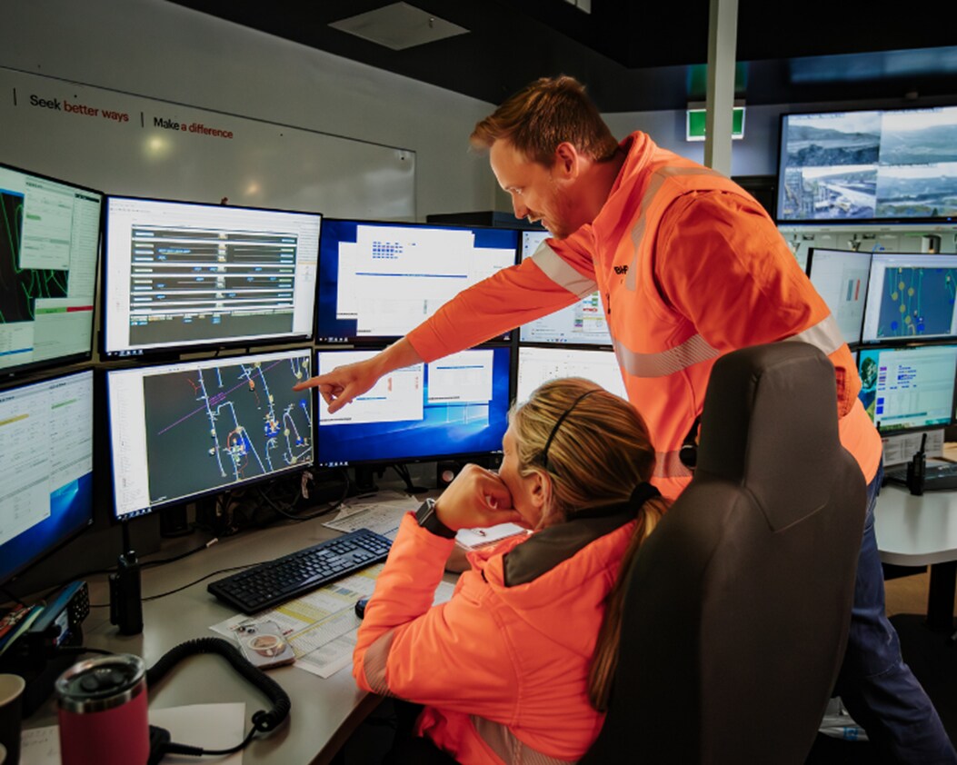 Image of two people discussing what is happening on the computer screen