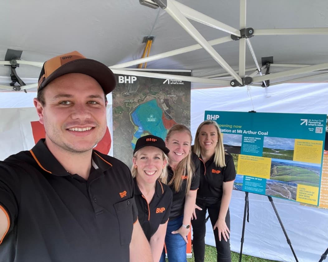 Image of 4 people at BHP exhibit at a community event