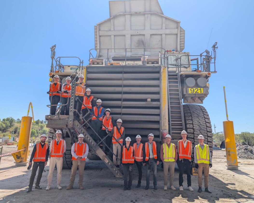 Group of people standing in front of large truck