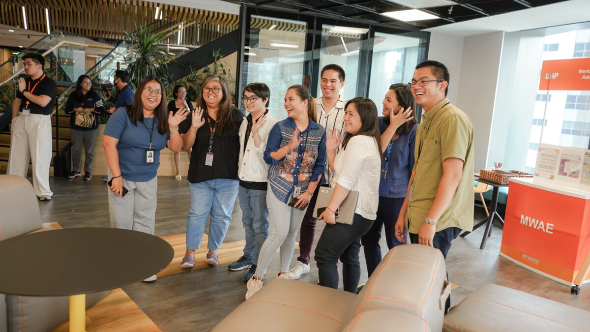 Group of people standing in BHP office smiling for team photo 