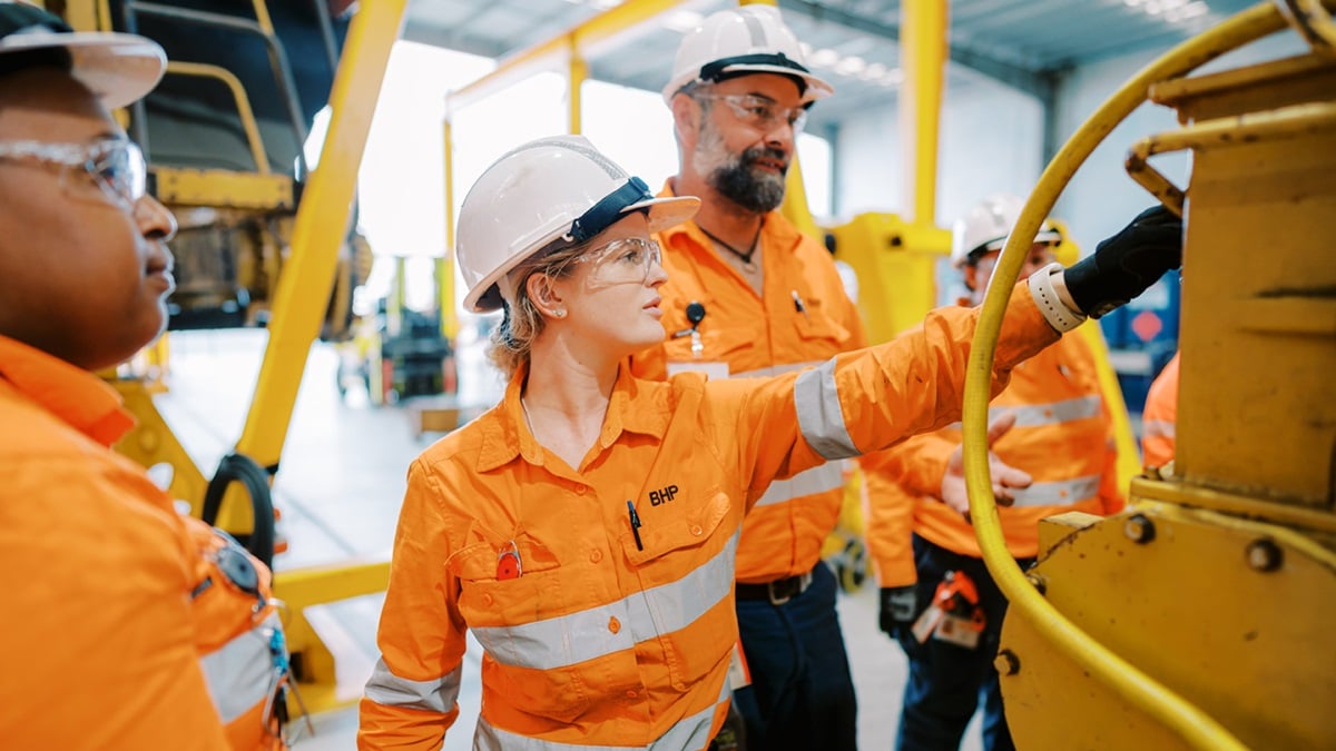 People shown in BHP orange PPE in a learning environment workshop