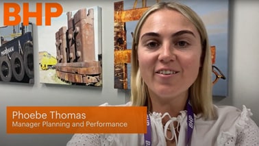 Woman shown inside BHP office smiling and talking about mt arthur coal