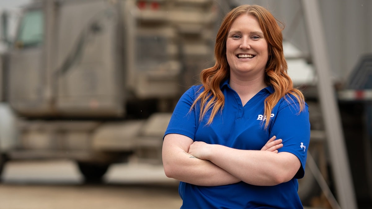 Woman in front of truck in BHP blue shirt smiling at Jansen site