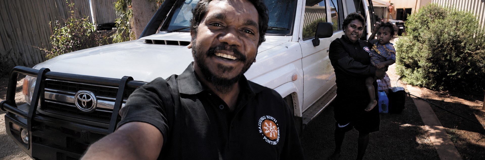 People taking a selfie in front of a truck