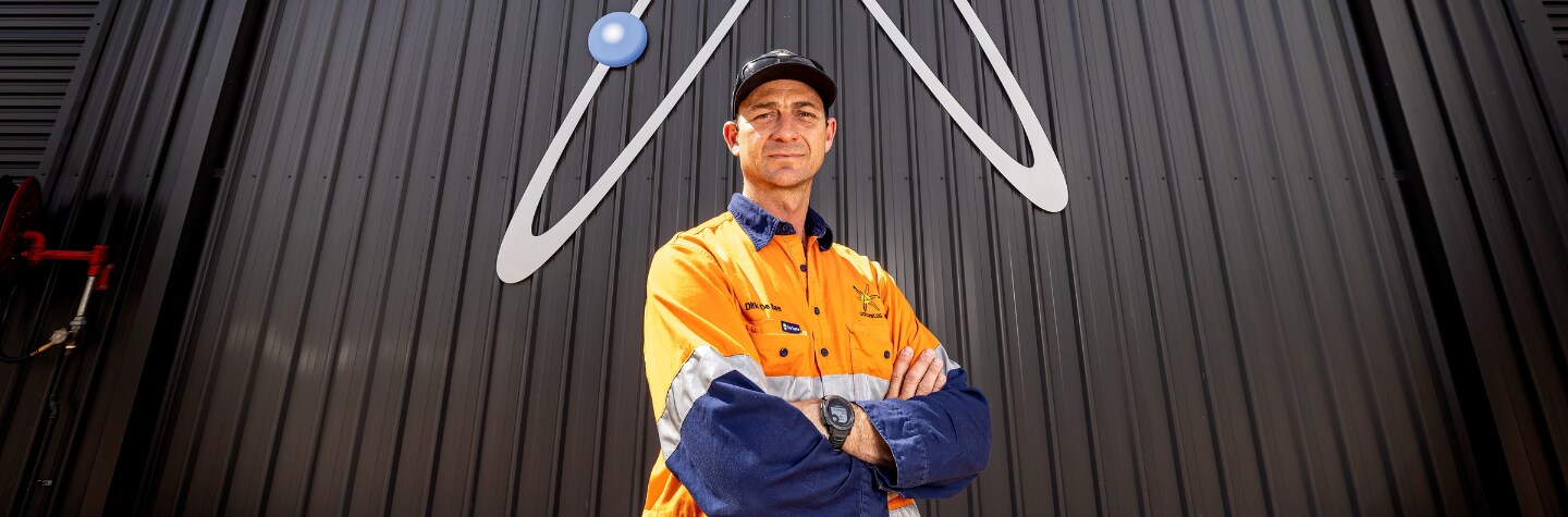 man staring into camera in mining uniform arms folded