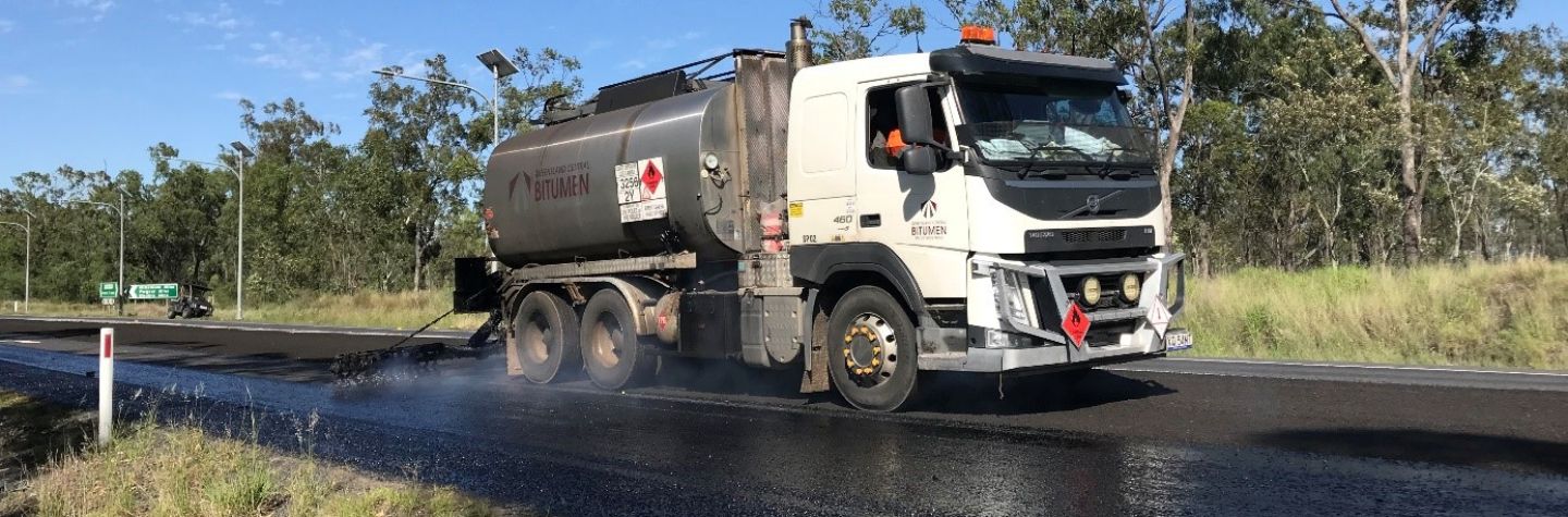 bitumen being laid on a road by a truck