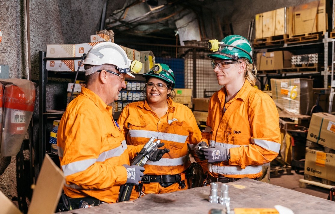 3 people in orange high vis talking
