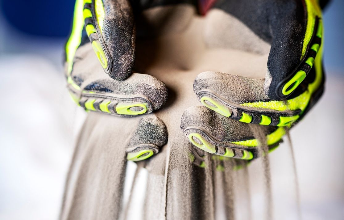 silt sifting through gloved hand