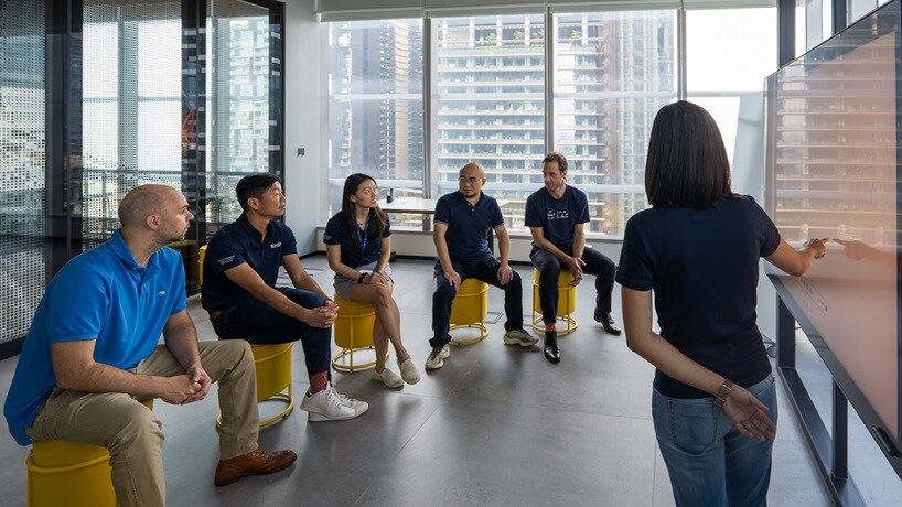 People learning in BHP Singapore office shown with whiteboard