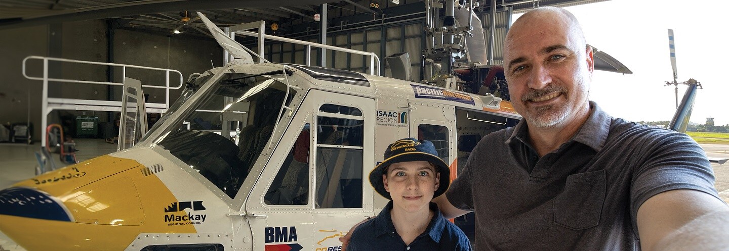 People smiling in front of helicopter