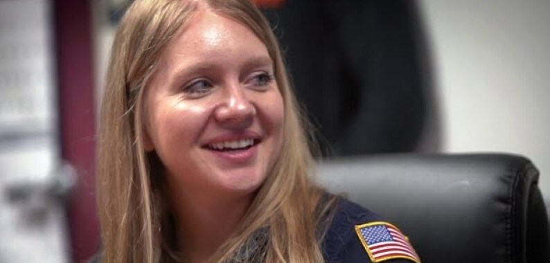 smiling woman with US flag shoulder badge