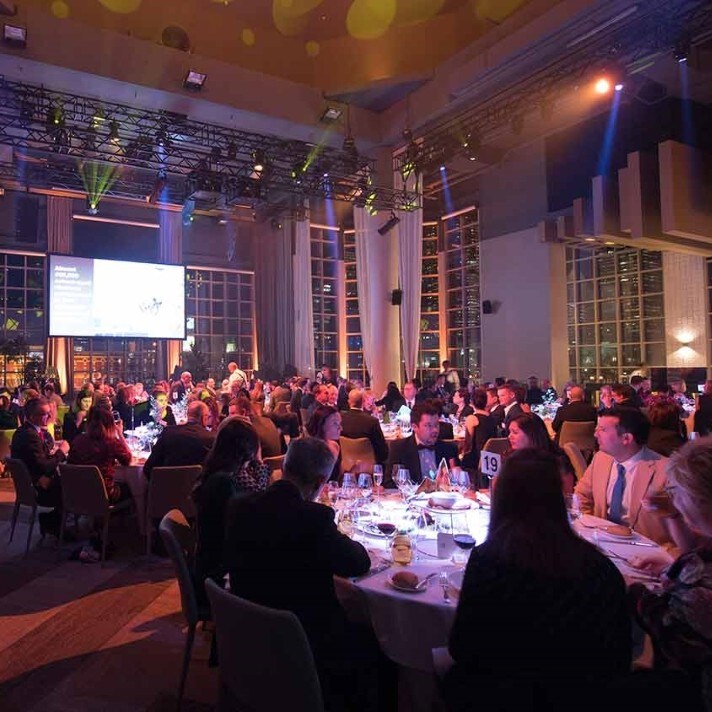 Many people sitting at tables at an event