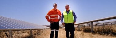 Two people in a field of solar panels