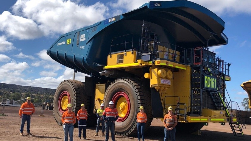 giant coal truck towers over workers