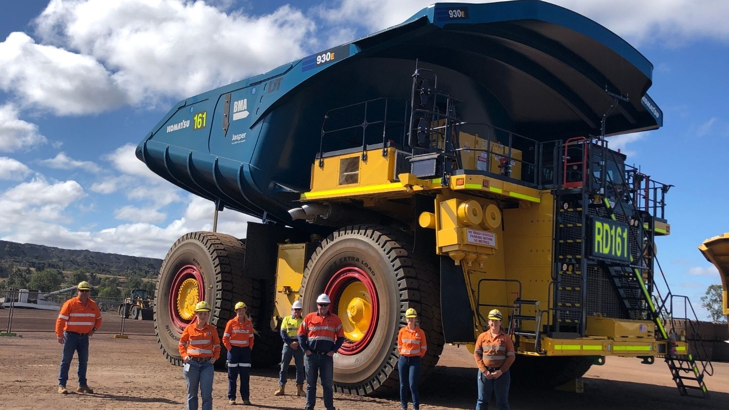 giant coal truck towers over workers